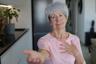 Senior woman begging for something with hand gesture clipart