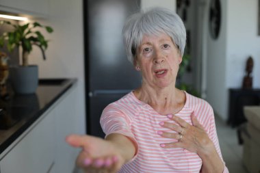 Kıdemli kadın el hareketleriyle bir şeyler istiyor.