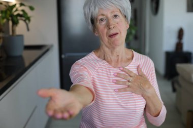 Senior woman begging for something with hand gesture clipart