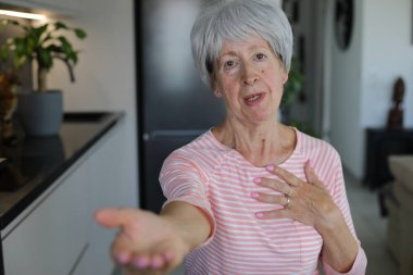 Kıdemli kadın el hareketleriyle bir şeyler istiyor.