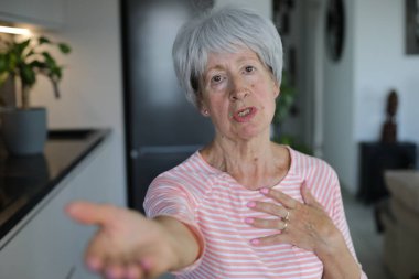 Kıdemli kadın el hareketleriyle bir şeyler istiyor.