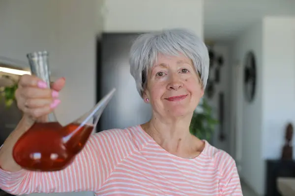 stock image Senior woman drinking with traditional Spanish utensil called 