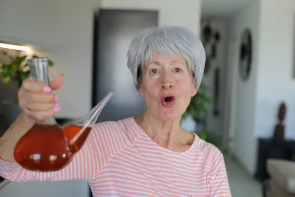 stock image Senior woman drinking with traditional Spanish utensil called 