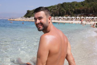 Genç adam yazın plajda dinleniyor.