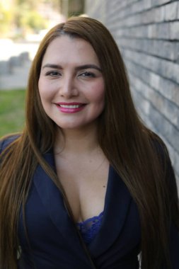 Şehirde ceketle poz veren çekici İspanyol kadın.