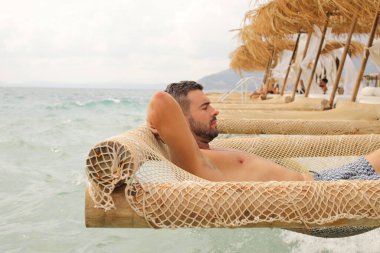 Yakışıklı adam askıya alınmış ağda yatıyor. 