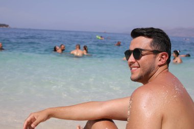 Kumsalda genç ve yakışıklı bir adam