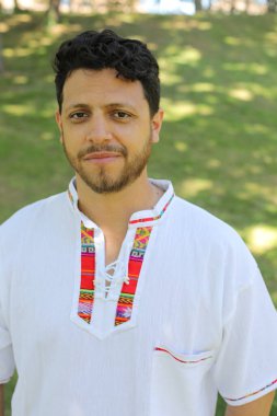 Beyaz gömlekli, gülümseyen kameraya bakan İspanyol adamın portresi.