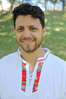 Beyaz gömlekli, gülümseyen kameraya bakan İspanyol adamın portresi.