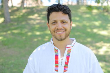 Beyaz gömlekli, gülümseyen kameraya bakan İspanyol adamın portresi.