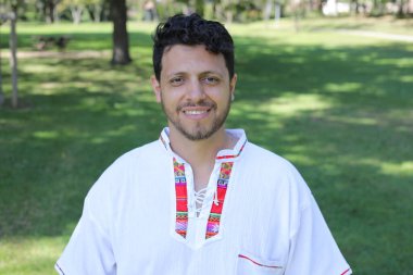 Beyaz gömlekli, gülümseyen kameraya bakan İspanyol adamın portresi.