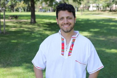 Beyaz gömlekli, gülümseyen kameraya bakan İspanyol adamın portresi.