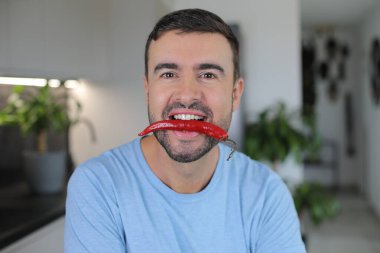 Ağzında çok baharatlı bir malzeme tutan bir adam.