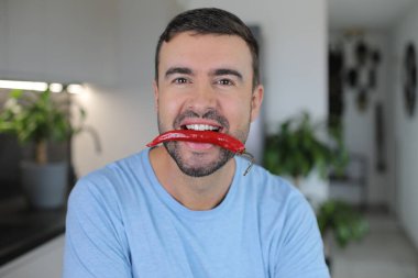 Ağzında çok baharatlı bir malzeme tutan bir adam.