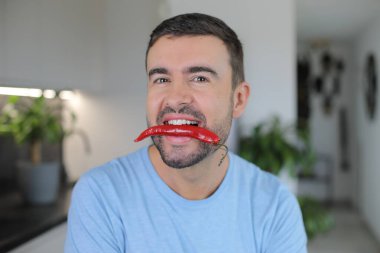 Ağzında çok baharatlı bir malzeme tutan bir adam.