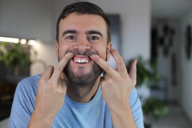 Sakallı adam diş etlerini gösteriyor, kapat.