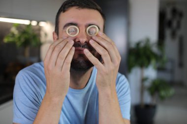 Evde gözlerinde prezervatif olan bir adam var. Yakın plan.