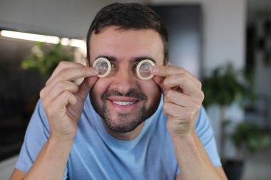 Evde gözlerinde prezervatif olan bir adam var. Yakın plan.