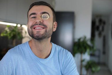 Evde gözlerinde prezervatif olan bir adam var. Yakın plan.