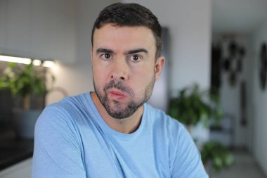 Sinir krizi geçirmek üzere olan sinirli görünüşlü bir adam.