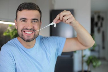 Yakışıklı adam sakızını esnetiyor.