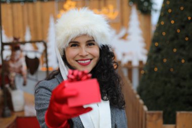 Noel zamanı elinde kırmızı bir hediye kutusu tutan bir kadın.