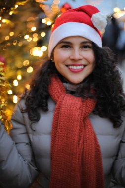 Kış şehrinde Noel Baba şapkalı genç bir kadın.