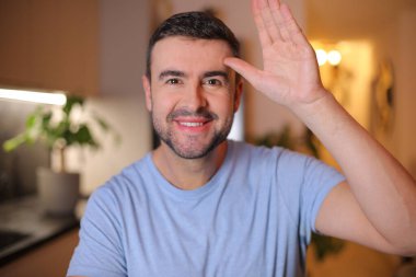 Evde işaret gösteren genç bir adam.