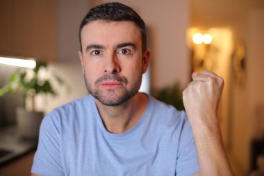 Evde işaret gösteren genç bir adam.