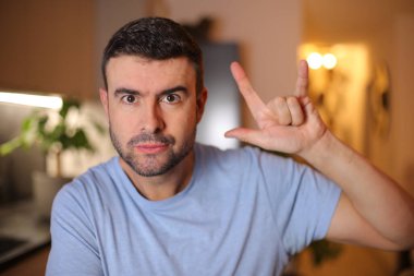 Evde işaret gösteren genç bir adam.