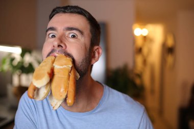 Tedirgin adam aynı anda çörek yiyor.