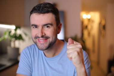 Evde işaret gösteren genç bir adam.