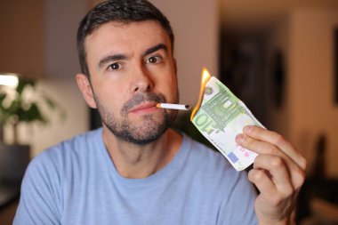 Adam sigarasını yakmak için 100 avro yakıyor.