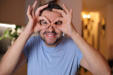 Evde işaret gösteren genç bir adam.