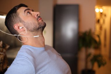 Eski moda kulaklık kullanan bir adam kendini rahatsız hisseder.