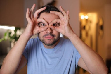 Evde işaret gösteren genç bir adam.