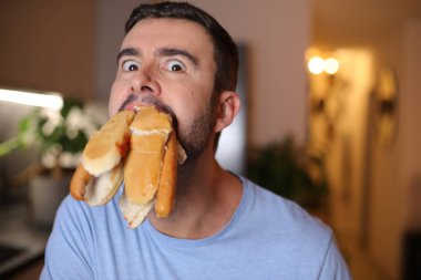 Tedirgin adam aynı anda çörek yiyor.