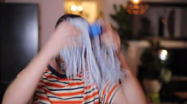 Oturma odasında kafasında bez parçasıyla genç bir adam.