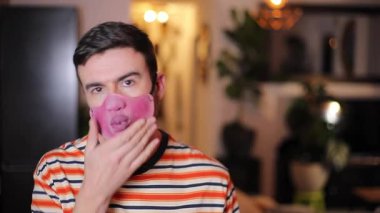 Adam evde ürkütücü bir maske takıyor.