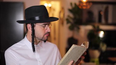 Kitap okuyan yakışıklı, geleneksel Yahudi adam. 