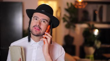 Kitap adn telefon ile yakışıklı geleneksel Yahudi adam
