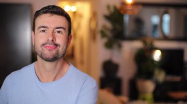 Yakışıklı adam oturma odasında oturuyor.