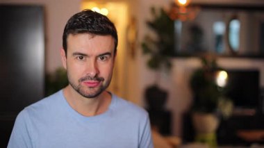 Yakışıklı adam oturma odasında oturuyor.