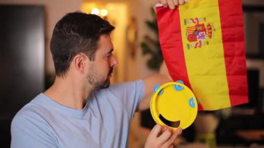 Evde İspanyol bayrağı ve tef çalan yakışıklı bir adam.