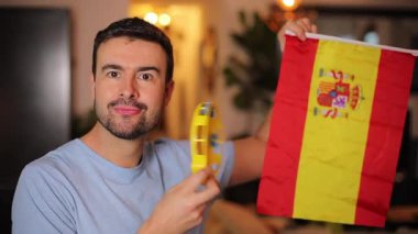 Evde İspanyol bayrağı ve tef çalan yakışıklı bir adam.