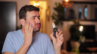 Evdeki adam kendi dişini çıkarıyor.