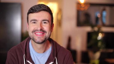 Evde kapüşonlu giyen yakışıklı bir adam.