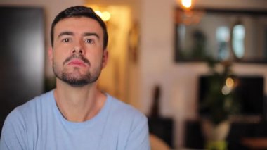 Mutsuz adam evde sahte bir gülümseme sergiliyor.