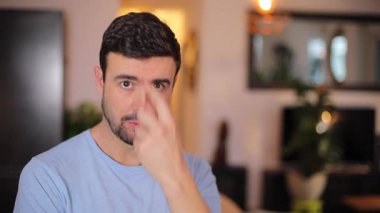 Genç adam bir oturma odasında dua ediyor.