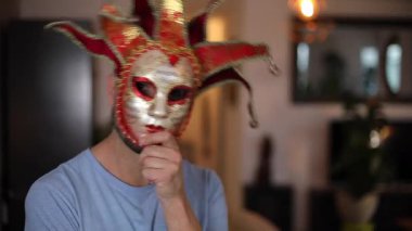 Genç yakışıklı adam karnavalda maske takıyor.
